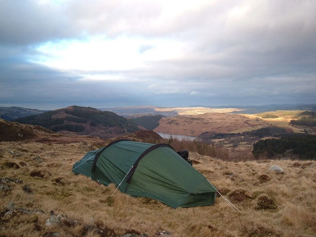 Small tent pitched on open moorland at dusk
